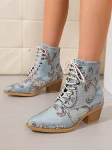 Detaillierte Nahaufnahme hellblauer Satin-Stiefeletten mit eleganter Vintage-Blumenstickerei