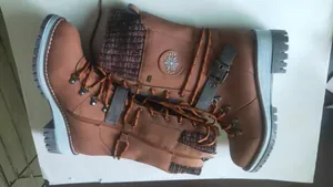 Side detail of brown mid-calf boots with buckle, side zipper and knitted collar.