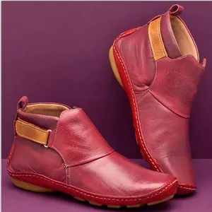 Detaillierte Makroansicht roter flacher Stiefeletten aus weichem Leder mit Klettverschluss