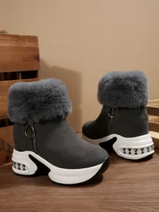 Detail view of warm women's grey snow boots with faux fur trim and platform soles.
