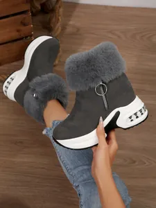 Detail of women's grey platform snow boots with fluffy faux fur and side zipper