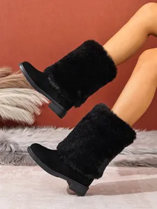 Detailed view of black faux fur high-top boots with chunky heels on model's legs