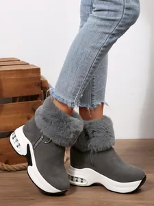 Close-up of women's gray faux fur snow boots with platform sole and side zipper.