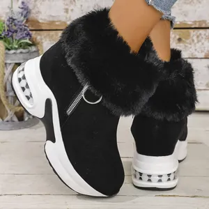 Detail of black winter snow boots with plush faux fur trim and chunky platform wedge sole.