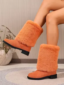 Close-up detail of orange faux fur suede boots featuring thick plush trim and chunky heels