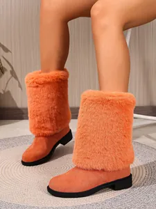 Close-up of vibrant orange furry boots with a comfortable block heel and round toe.