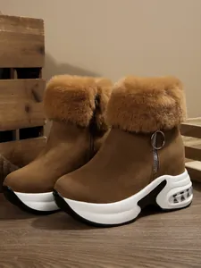 Side detail view of brown winter snow boots featuring lush faux fur trim and thick platform soles
