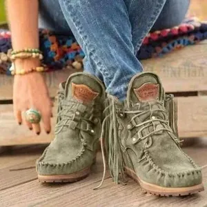 Close-up of green suede fringe ankle boots with bohemian western style lace-up design