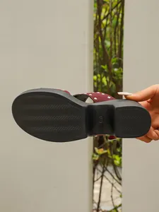 Detailed view showing wavy anti-slip texture on wine red studded platform sandal sole