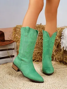 Detailed view of green suede western boots with intricate embroidery