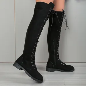 Détail des bottes cuissardes en daim noir avec lacets et fermeture éclair sur le côté