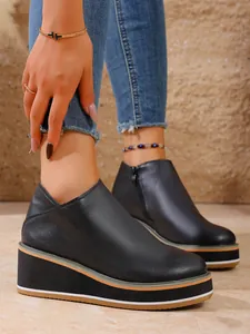 Detailansicht der schwarzen Keilstiefeletten für Damen mit Plateausohle