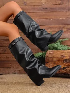 Detailed view of black pleated knee-high boots featuring pointed toe and chunky heel.