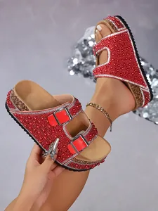 Detail of red platform cork slides decorated with pearls, rhinestones and double buckles.