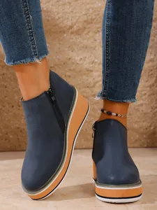 Detailansicht blauer Keilstiefeletten mit Reißverschluss und gestreifter Plateausohle