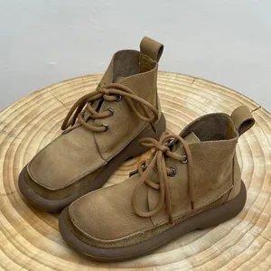 Detailed view of vintage tan leather Martin boots with thick soles and round toes.