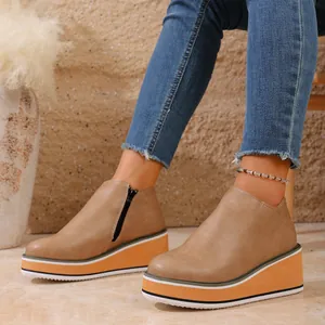 Vue détaillée de bottines compensées marron pour femme avec une semelle plateforme orange.