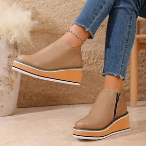Détail de bottines à plateforme et talon compensé beige avec fermeture éclair latérale