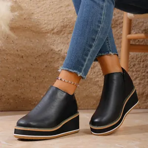 Détail de bottines noires à plateforme et talon compensé avec fermeture éclair latérale