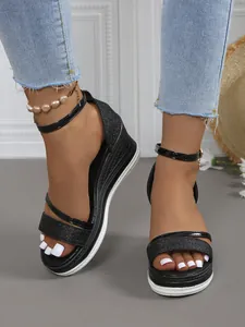 Detailansicht schwarzer Keilsandalen mit Plateausohle, Peeptoe-Design und geflochtener Sohle