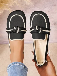 Detailopname van ademende zwart-witte gebreide loafers met een stijlvolle strik