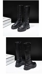 Detail view of black platform knee-high combat boots with side zipper and laces.