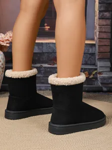 Detailopname van zwarte winterlaarzen voor dames met zachte beige imitatiebontrand.