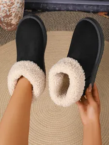 Detail van warme zwarte winterlaarzen met een dikke beige kraag van imitatiebont en pluche voering