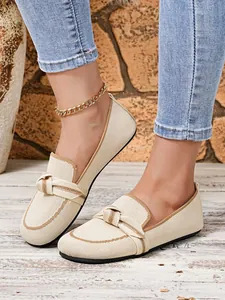Gedetailleerde close-up van beige flyknit loafers met een stijlvol knoopontwerp