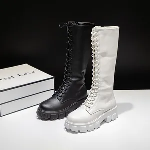Women's knee-high platform boots with thick soles and lace-up front in black and white