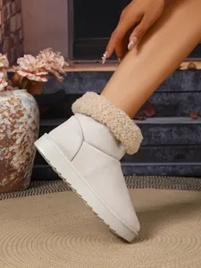 Close-up van beige wintersneeuwlaars met warme kraag van imitatiebont en suède afwerking