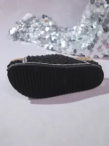 Detailed view of the non-slip rubber sole on black rhinestone cork slide sandals.