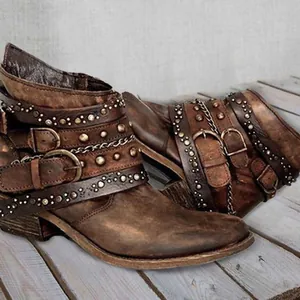 Vintage distressed brown leather ankle boots with buckle straps and metallic rivet details