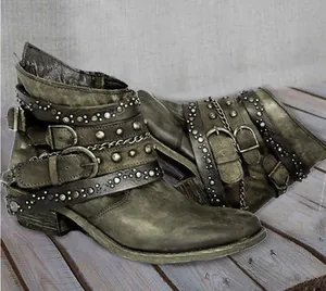 Vintage distressed leather Martin boots with decorative belt buckles and metal rivets.