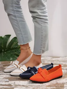 Stylish fly-knit pointed-toe flat shoes with bow detail in white, blue, and orange.