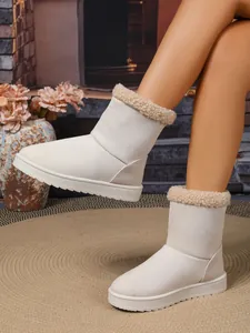 Detailweergave van warme gebroken witte snowboots met pluche rand en suède afwerking