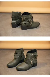 Close-up detail of olive green ankle boots with decorative straps, buckles and chains