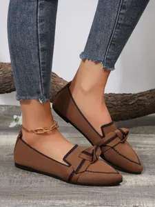 Close-up of brown fly-woven flat loafers featuring a stylish bow and breathable mesh.