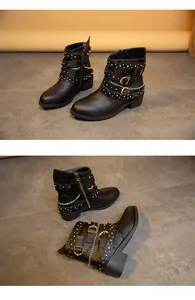 Detailed macro shot of black women's punk style ankle boots with metal buckles and chains