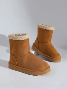 Detailweergave van warme bruine suède sneeuwlaarzen voor dames met een zachte pluche kraag.