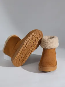 Detailopname van bruine sneeuwlaarzen met dikke imitatiebontvoering en antislipzool