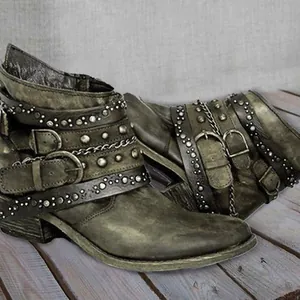 Vintage brown leather ankle boots featuring multiple buckle straps and silver rivet details.