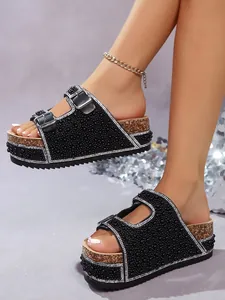 Detailed view of women's black rhinestone double buckle sandals with cork platform