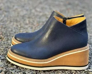 Detail of navy blue leather wedge ankle boots with side zipper and thick platform sole