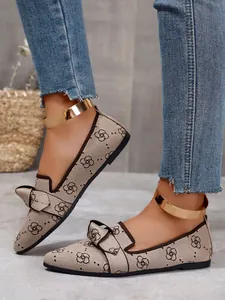Close-up of beige fly-knit pointed flats featuring bow detail and gold metallic ankle strap