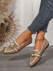 Close-up of women's beige fly-knit pointed loafers featuring a stylish bow detail