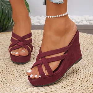 Burgundy suede wedge sandals with criss-cross straps and platform peep-toe summer design.