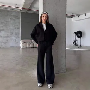 Schickes schwarzes zweiteiliges Fleece-Trainingsset mit Reißverschlussjacke und weiter Hose.