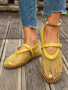 Détail de chaussures Mary Jane plates en maille jaune respirante portées en extérieur