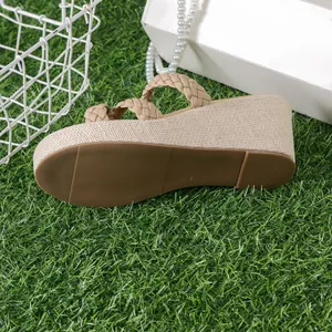 Side view of beige platform wedge sandal with woven straps on green grass background